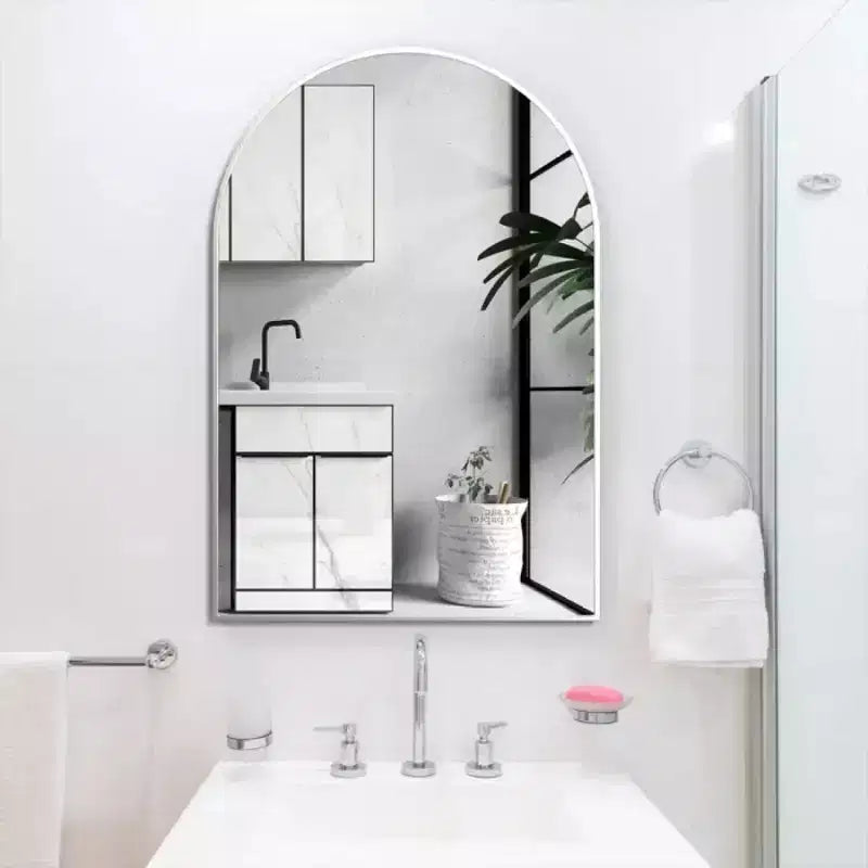 Miroir de salle de bain mural arqué à cadre métallique noir.